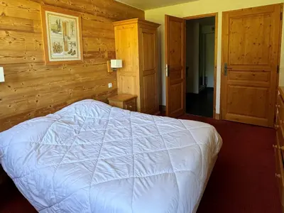 Un ou plusieurs lits dans un hébergement de l'établissement Appartement cosy avec accès direct aux pistes, espace bien-être et piscine chauffée - FR-1-181-2813