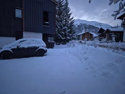 L'établissement Le Nid Douillé du Crêt, parking et terrasse en hiver
