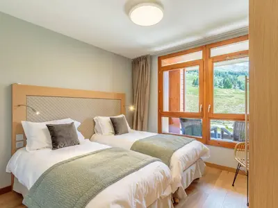 Un ou plusieurs lits dans un hébergement de l'établissement Superbe 4 pièces moyen pour 6 pers. avec piscine, spa, fitness, parking couvert, ski aux pieds - FR-1-352-68