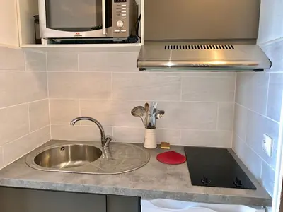 Cuisine ou kitchenette dans l'établissement Appartement accueillant et lumineux Proche des pistes et des commerces Balcon - FR-1-502-322